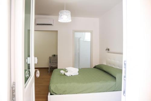 a bedroom with a bed with a green blanket at Acquasanta Relais in Laureana Cilento