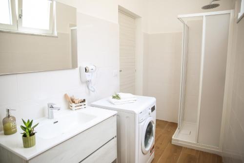 a white bathroom with a washing machine and a sink at Acquasanta Relais in Laureana Cilento