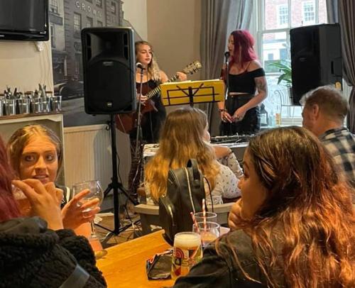 a group of people sitting around a table with a microphone at The Crown Fakenham in Fakenham