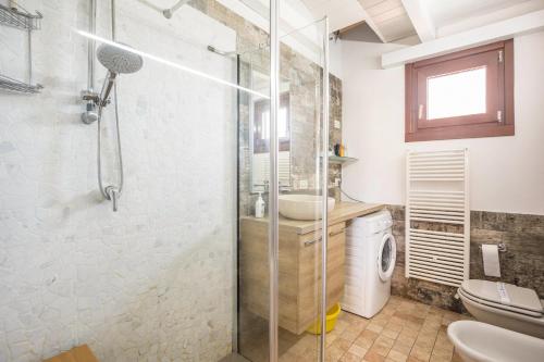 un bagno con doccia in vetro e WC di Maloma a Peschiera del Garda