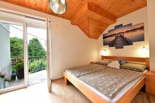 - une chambre avec un lit et une grande fenêtre dans l'établissement Rooms Toni, à Selište Drežničko