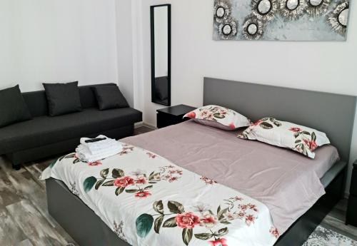 a bedroom with a bed and a couch at APARTAMENT E'SPECIAL No3 ALBA IULIA in Alba Iulia
