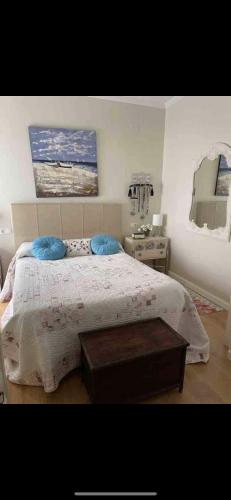 um quarto com uma cama com duas almofadas azuis em Punta umbria sol y mar em Punta Umbría