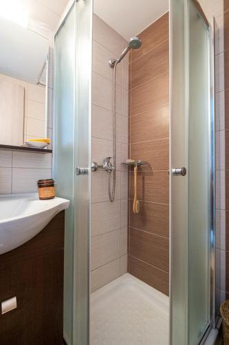 a shower with a glass door in a bathroom at Attico Blu - Sea View Penthouse in Kos