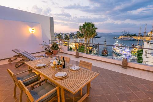 a wooden table on a balcony with a view of the water at Attico blu - Sea View Penthouse in Kos