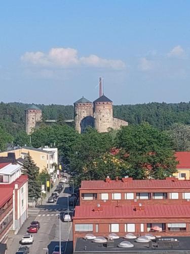 a city with a castle on top of a hill at Malminranta in Savonlinna