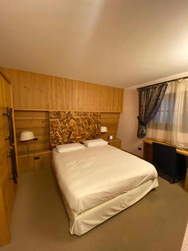 a bedroom with a large bed and a television at Hotel Bait de Angial in Livigno