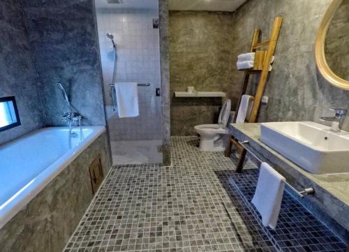 a bathroom with a tub and a sink and a toilet at ChiangMai清迈 cozy pool Villa 8rooms in Chiang Mai