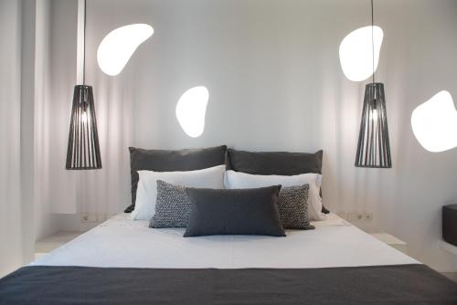 a bedroom with a bed with three lights above it at Passa Corda Suites with amazing view in Galanado