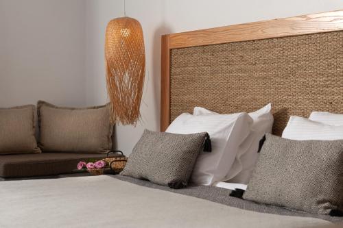 a bedroom with a bed with pillows and a couch at Smy Mediterranean White Santorini in Kamari