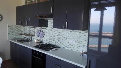 uma cozinha com um lavatório e um fogão forno superior em Scario Sunny Apartment in centro em Scario