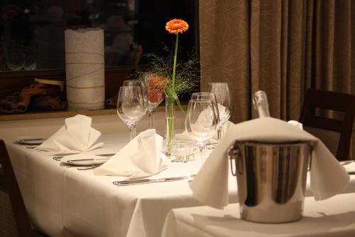 a table with wine glasses and a flower on it at Hotel Scheffelhöhe in Bruchsal