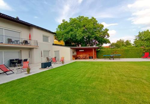 un patio trasero con césped, mesa y sillas en Appartementhaus Thermeneck, en Laa an der Thaya