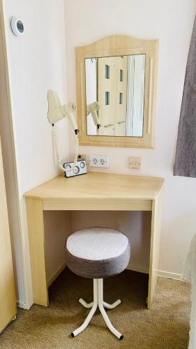 a desk with a chair and a mirror at Ferienhaus Vienna am Kronensee in Ostercappeln