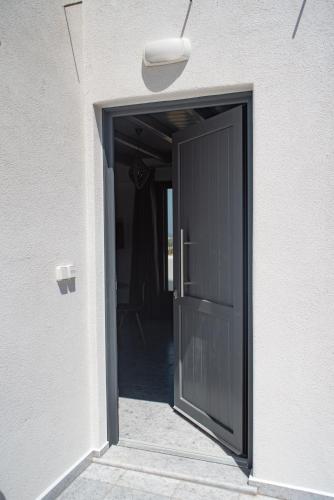 a black door leading into a hallway of a house at Passa Corda Suites with amazing view in Galanado