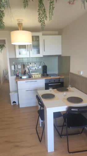 une cuisine avec une table et des chaises dans une pièce dans l'établissement Le hameau des 4 saisons 5 personnes, à Bolquère-Pyrénées 2000