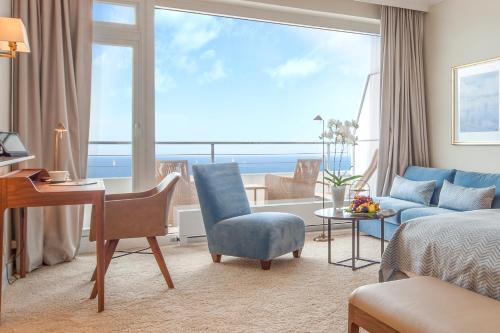 ein Hotelzimmer mit einem Bett, einem Schreibtisch und einem Zimmer in der Unterkunft Grand Hotel Seeschlösschen Sea Retreat & SPA in Timmendorfer Strand
