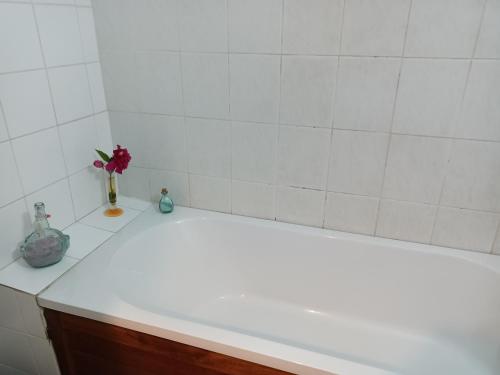 een badkamerbar met een vaas met een bloem erin bij blue and yellow, appartement au calme, avec piscine, WIFI in Saint-Denis