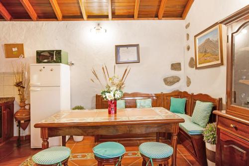 a kitchen with a table and chairs and a refrigerator at Casita Roque Nublo in Tejeda