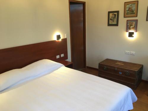 a bedroom with a large white bed and a nightstand at La casa de Teresita in La Paz