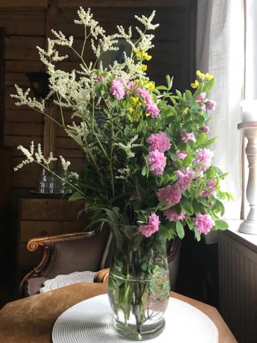 a vase filled with pink and yellow flowers on a table at Päivin pirtti - Pirttikahvila ja B&B in Luosto