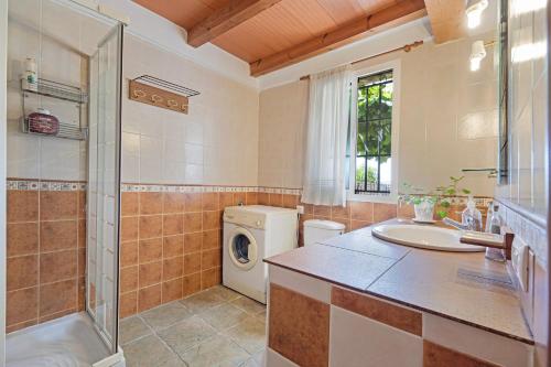 a bathroom with a sink and a washing machine at Casa Andrea in Barbate