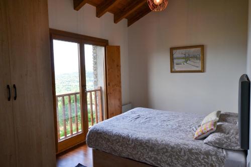 a bedroom with a bed and a large window at El turó d'Enveig in Enveitg