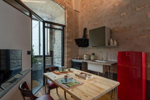 a kitchen with a wooden table and a red refrigerator at Il Quinto Elemento - Residence Of Charme in Ostuni