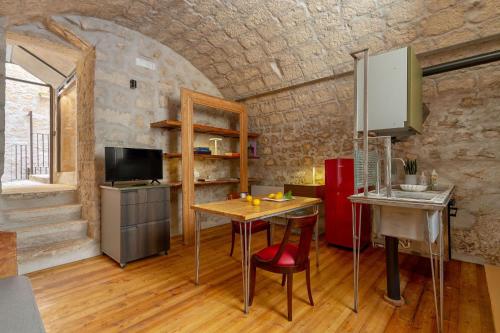 a kitchen with a table and a red refrigerator at Il Quinto Elemento - Residence Of Charme in Ostuni