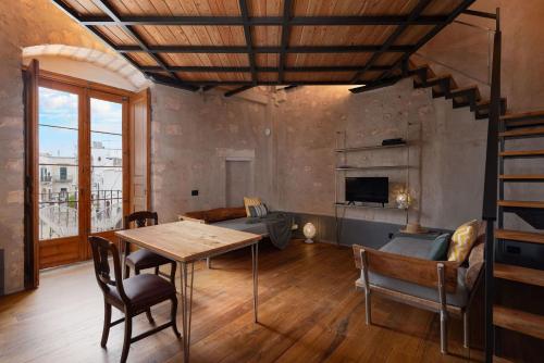 a living room with a table and a couch at Il Quinto Elemento - Residence Of Charme in Ostuni