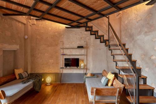 a living room with a staircase and a couch at Il Quinto Elemento - Residence Of Charme in Ostuni