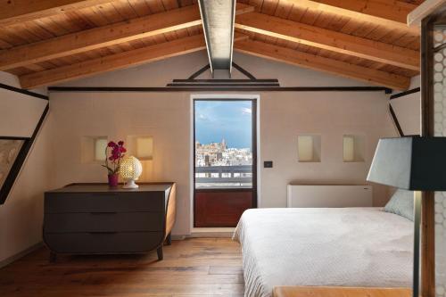 a bedroom with a bed and a window with a view at Il Quinto Elemento - Residence Of Charme in Ostuni