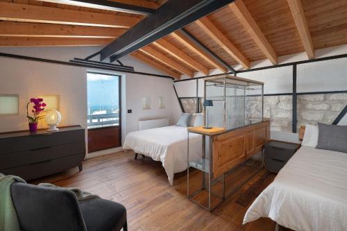 a bedroom with two beds and a desk and a window at Il Quinto Elemento - Residence Of Charme in Ostuni