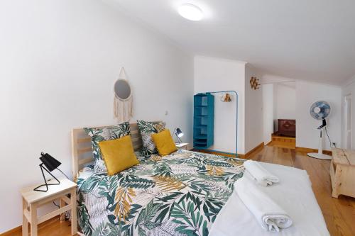 a bedroom with a large bed with yellow pillows at Casa Canopa in Setúbal