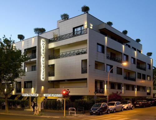 a white building with cars parked in front of it at Hotel Pulitzer in Rome