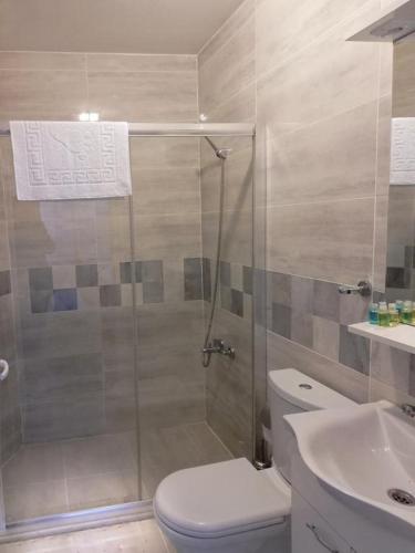 a bathroom with a shower and a toilet and a sink at Yağız İndigo Blue in Şile