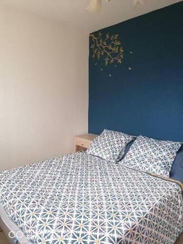 a bedroom with a bed with a blue wall at Bain de soleil in Forcalquier