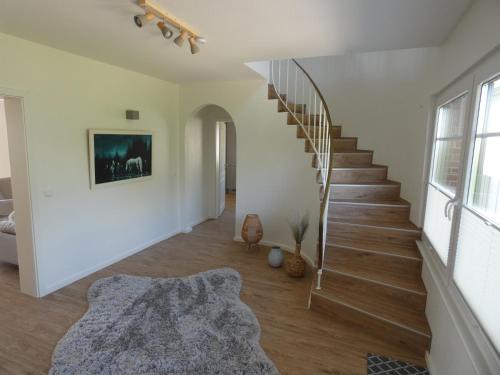 einen weißen Flur mit Wendeltreppe in einem Haus in der Unterkunft Ferienhaus "Hof Balkähm" mit 200 qm für bis zu 9 Gäste - Sauna - Landhausgarten in Norddeich