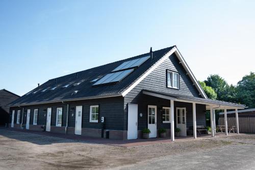a house with solar panels on the roof at Holiday home de Stamhoeve in Biezenmortel