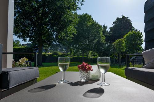 two glasses of white wine sitting on a table at Holiday home de Stamhoeve in Biezenmortel