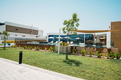 a building with a lawn in front of it at Relaxing villa with access to pool and beach in Ras al Khaimah