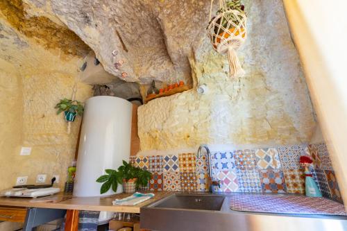 a kitchen with a sink and a stone wall at TerràThana in Saint-Aignan