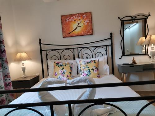 a bedroom with a black bed with pillows and a mirror at Nely's Luxury Home in Nydri