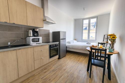 - une cuisine avec une table et un lit dans une chambre dans l'établissement Le Studio BILOBOU, à Noyers-sur-Cher