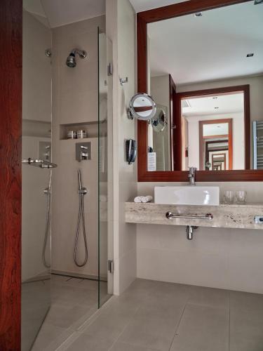 a bathroom with a sink and a mirror and a shower at Hotel SPA Dr Irena Eris Krynica Zdrój in Krynica Zdrój