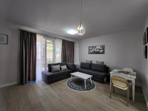 un salon avec un canapé et une table dans l'établissement Lovely 1-Bedroom Apartment at San Pietro Beach Front Resort, à Mullini i Danit