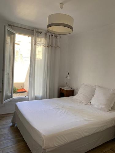 une chambre avec un lit blanc et une fenêtre dans l'établissement Lumineux extérieur proche gare et stationnement privé, à Avignon