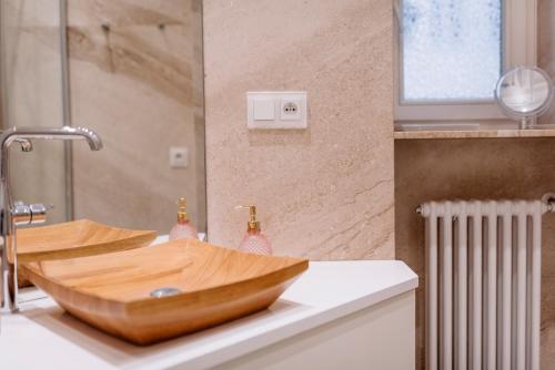 a bathroom with a wooden bowl sink on a counter at APARTEL LUX Plac Unii 72m2 in Warsaw
