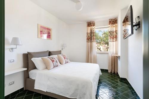 a white bedroom with a bed and a window at Don Leonardo - pool and wellness in Polignano a Mare