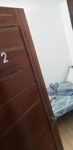 a wooden door with a bed in a room at Strandhaus Condotel in Moalboal